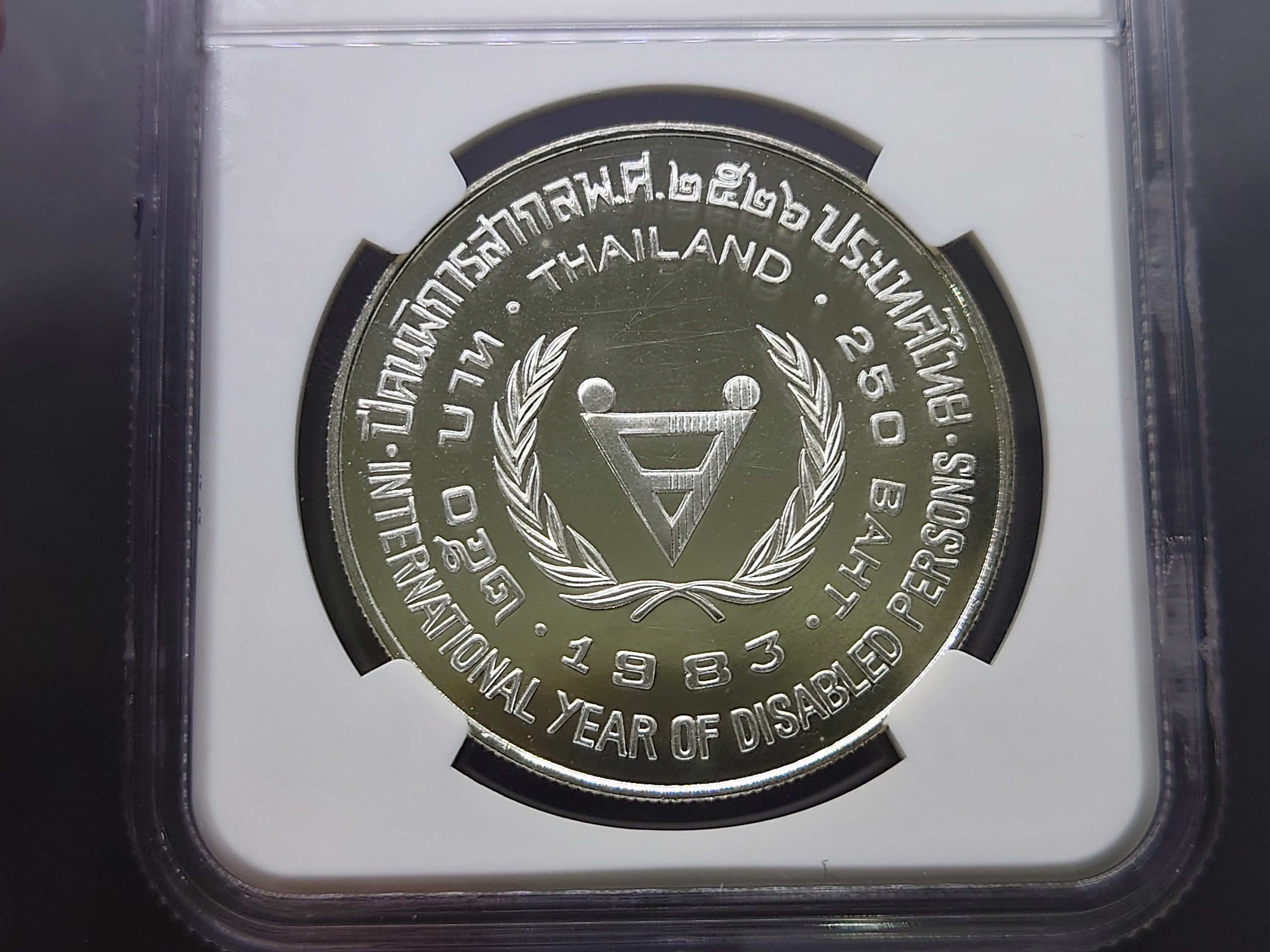 เหรียญเกรด เหรียญเงิน 250 บาท ที่ระลึกปีคนพิการสากล MS 64 NGC พ.ศ.2526 พร้อมกล่องเดิมและใบเซอร์ (หายากมาก)