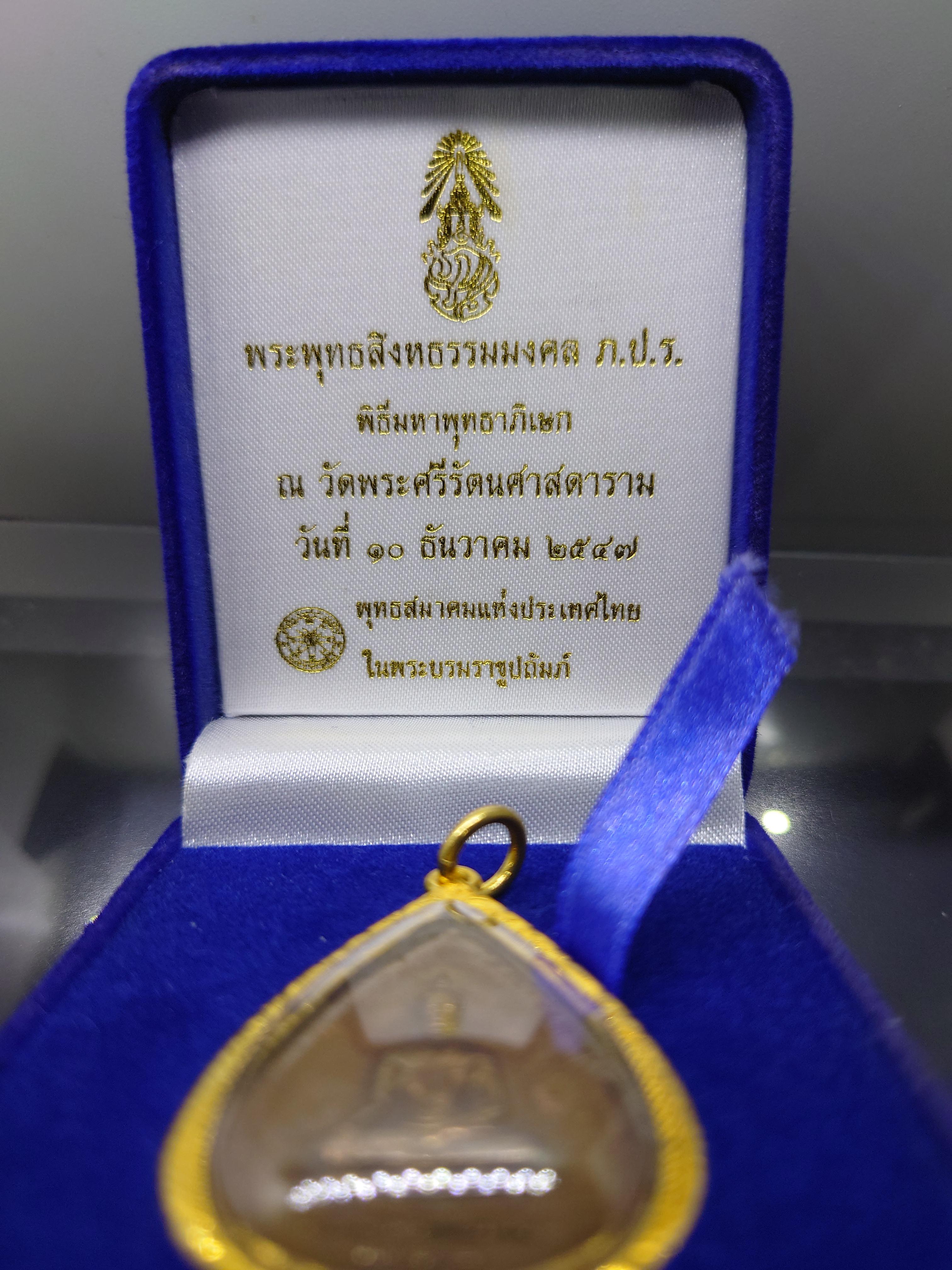 พระพุทธสิงหธรรมมงคล หลังพระปรมาภิไธย ภ.ป.ร. เนื้อนวะ พุทธสมาคมแห่งประเทศไทย ในพระบรมราชูปถัมภ์ พ.ศ.2547 เลี่ยมกรอบทองนพเก้า พร้อมตลับเดิม