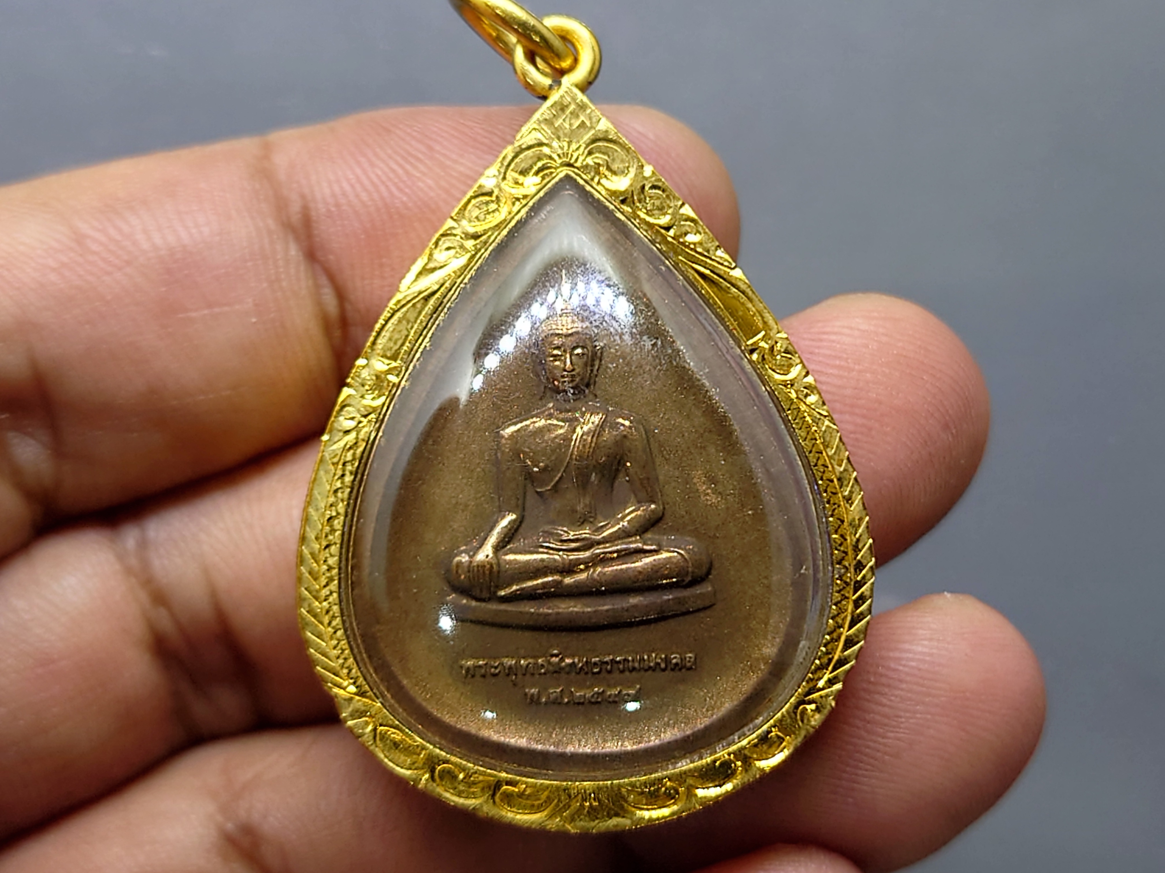 พระพุทธสิงหธรรมมงคล หลังพระปรมาภิไธย ภ.ป.ร. เนื้อนวะ พุทธสมาคมแห่งประเทศไทย ในพระบรมราชูปถัมภ์ พ.ศ.2547 เลี่ยมกรอบทองนพเก้า พร้อมตลับเดิม