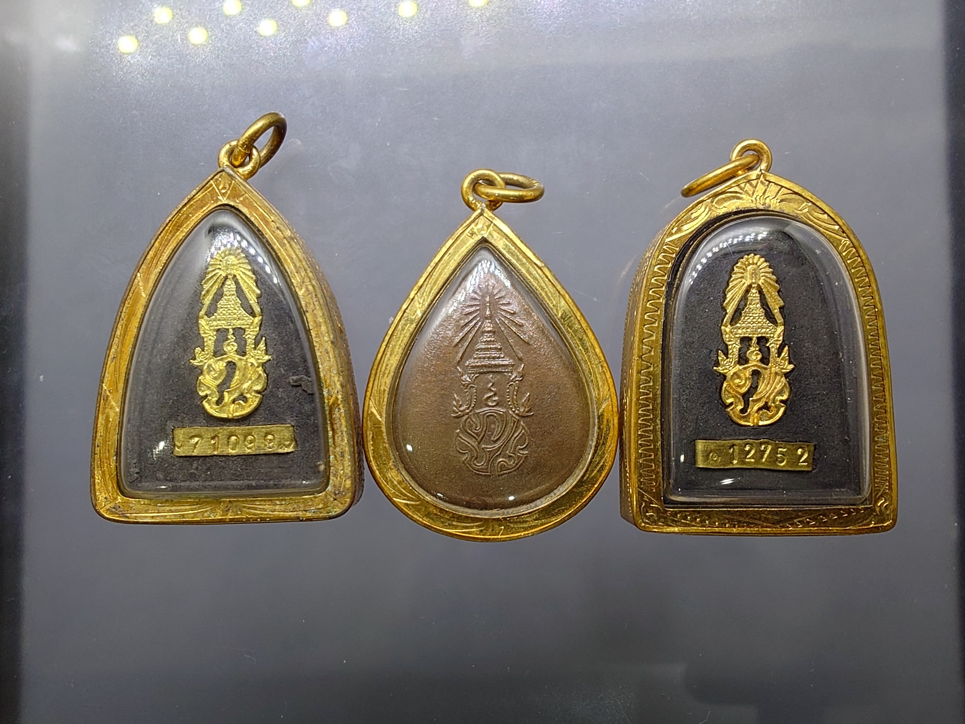 หลวงปู่ทวด ภ.ป.ร. เนื้อว่าน ทรงกลีบบัว (พิมพ์เตารีด) และกลีบขนุน พระพุทธสิงหธรรมมงคล เลี่ยมกรอบทองนพเกล้า พิธีพุทธาภิเษก ณ พระอุโบสถ วัดพระศรีรัตนศาสดาราม พ.ศ.2547 พร้อมกล่องเดิม