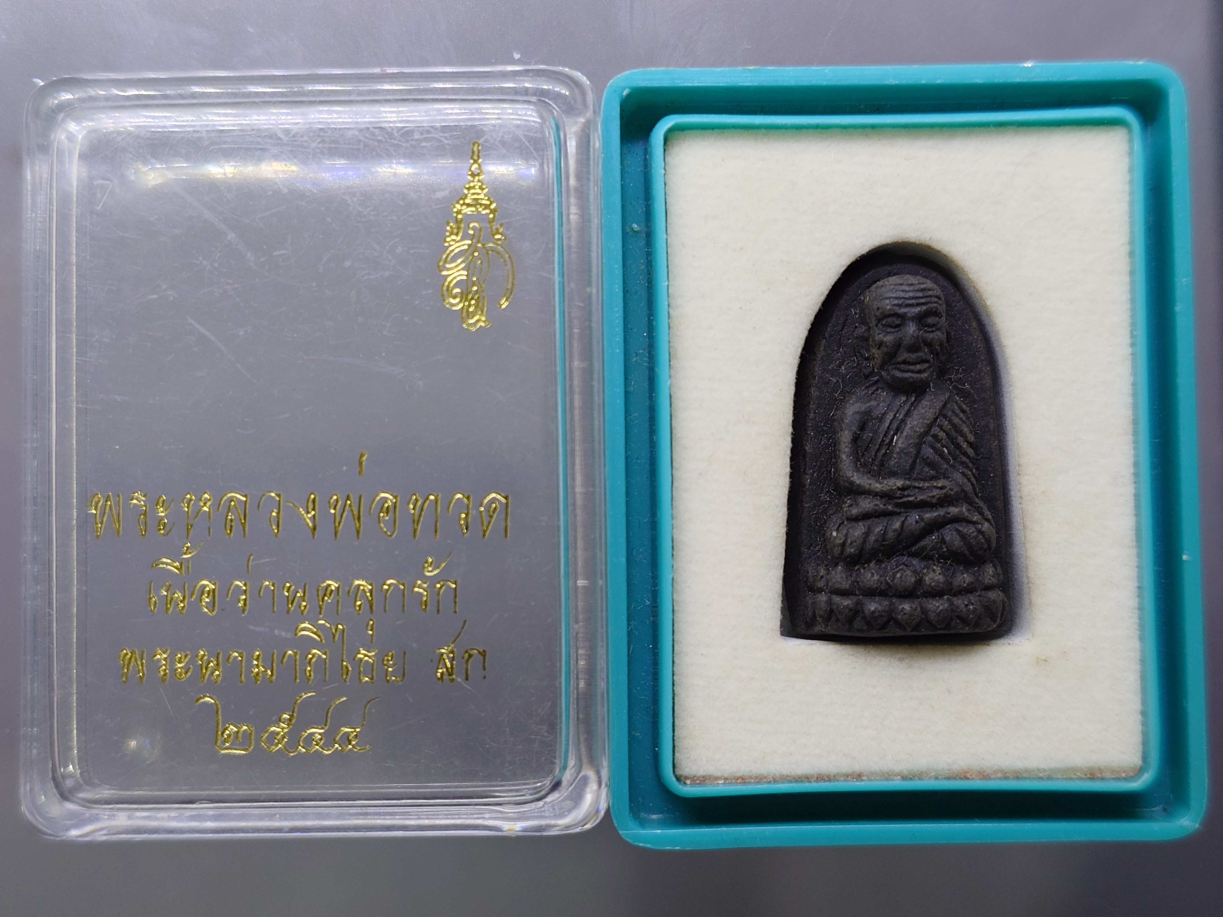 หลวงพ่อทวด พระนามาภิไธย สก. เนื้อว่านคลุกรัก พิมพ์พระรอด วัดห้วยมงคล ปี 2544 พร้อมกล่องเดิม