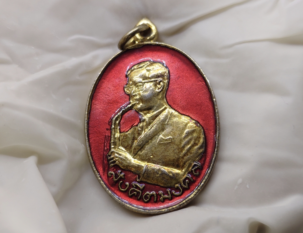 เหรียญสังคีตมงคล ในหลวง รัชกาลที่9 ทรงดนตรี เนื้อกะหลั่ยทอง ลงยาสีแดง ฉลองครบรอบ 21 ปี สมาคมดนตรีแห่งประเทศไทย ปี 2530 นิยม หายาก