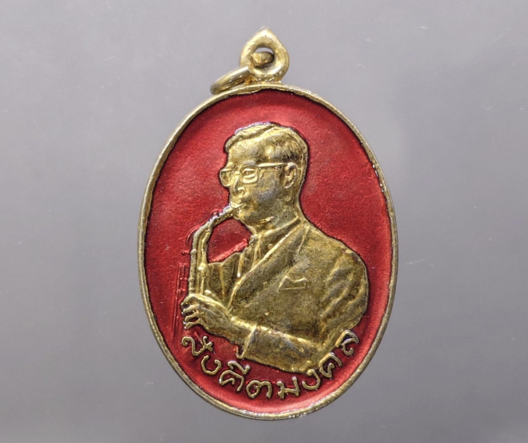 เหรียญสังคีตมงคล ในหลวง รัชกาลที่9 ทรงดนตรี เนื้อกะหลั่ยทอง ลงยาสีแดง ฉลองครบรอบ 21 ปี สมาคมดนตรีแห่งประเทศไทย ปี 2530 นิยม หายาก